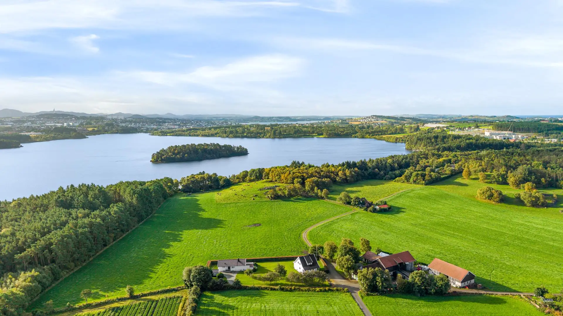 Gårdstun i åpent jærlandskap ved vannet